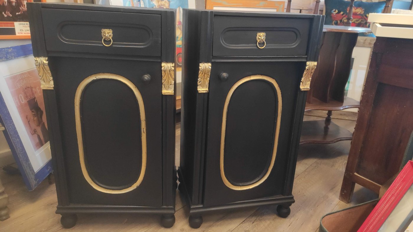 Coppia di comodini laccati in nero con decori dorati e maniglie in ottone